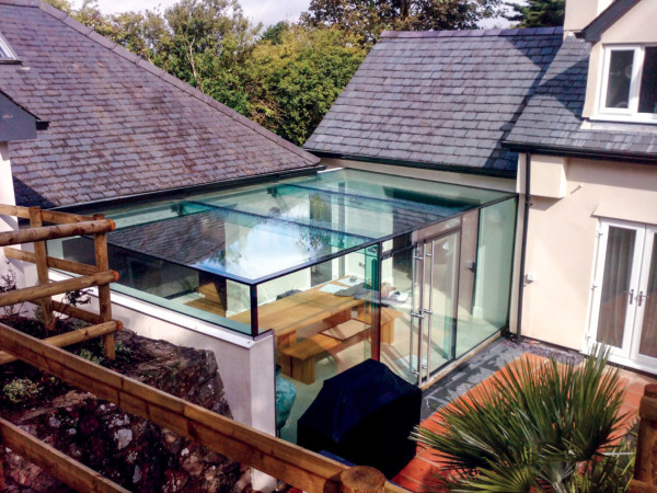 Solar control, frameless glass link conservatory featuring glass fins and beams.