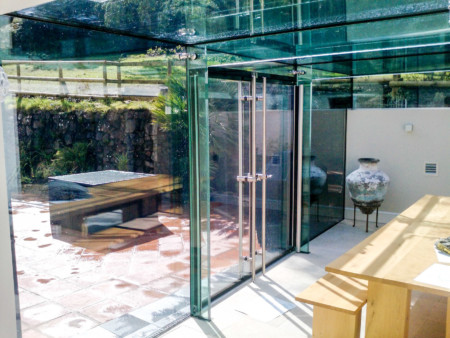 Solar control, frameless glass link conservatory featuring glass fins and beams.