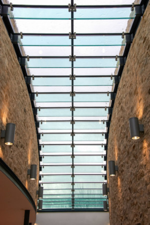 30 metre long fixed structural glass roof supported on glass beams.