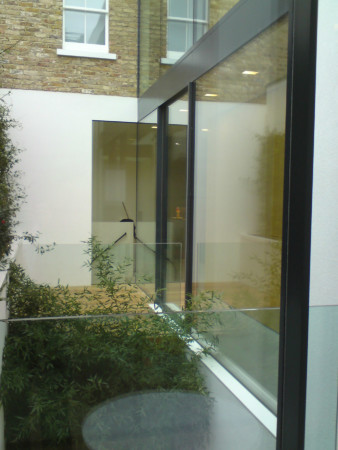 Structural glazing with frameless glass and Sky-Frame sliding doors.